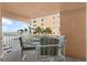 Oceanfront balcony features a small table and chairs with beach and pier views at 16308 Gulf Blvd # 209, Redington Beach, FL 33708