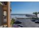 Partial ocean view from balcony showcasing beach, pier, and parking lot at 16308 Gulf Blvd # 209, Redington Beach, FL 33708