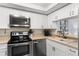 Updated kitchen with stainless steel appliances and white cabinetry at 16308 Gulf Blvd # 209, Redington Beach, FL 33708