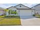 One-story home with attached garage, landscaping, and palm trees at 9316 Channing Hill Dr, Ruskin, FL 33573