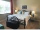 This main bedroom features a comfortable bed, lamps, and a window, creating a relaxing and inviting space for rest at 809 Chipper Dr, Sun City Center, FL 33573