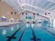 Indoor swimming pool with lane markers and decorative flags, perfect for recreation at 809 Chipper Dr, Sun City Center, FL 33573
