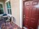 Inviting front entry with a burgundy door and small patio seating at 809 Chipper Dr, Sun City Center, FL 33573