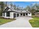 Two story home with gray and white exterior, two car garage, and paver driveway at 19411 Sheltered Hill Dr, Brooksville, FL 34601