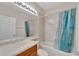 Bathroom with tub shower combination, single vanity, and teal shower curtain at 16216 Amethyst Key Dr, Wimauma, FL 33598