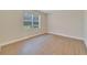 Spacious bedroom featuring wood-look floors and a window with blinds at 16216 Amethyst Key Dr, Wimauma, FL 33598