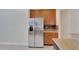 Stainless steel refrigerator and wood cabinets in kitchen at 16216 Amethyst Key Dr, Wimauma, FL 33598