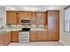 Kitchen with wood cabinets, granite countertops, and stainless steel appliances at 16216 Amethyst Key Dr, Wimauma, FL 33598