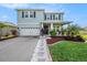 Two-story home with teal exterior, stone accents, and landscaping at 16632 Goose Ribbon Pl, Wimauma, FL 33598
