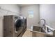 Laundry room with stainless steel sink and LG washer/dryer at 16632 Goose Ribbon Pl, Wimauma, FL 33598