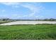 Scenic view of a lake with lush green grass at 16632 Goose Ribbon Pl, Wimauma, FL 33598