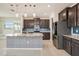 Modern kitchen with dark cabinets, granite counters, and blue tile backsplash at 16632 Goose Ribbon Pl, Wimauma, FL 33598