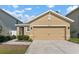 Tan house with two car garage and landscaped front yard at 10920 Carlton Fields Dr, Riverview, FL 33579