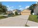 Tan house exterior with two-car garage and driveway at 10920 Carlton Fields Dr, Riverview, FL 33579