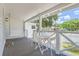 Charming front porch with white swing and small table set, perfect for relaxing outdoors at 5602 N Ola Ave, Tampa, FL 33604