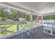 White porch with rocking chairs, table, and view of grassy yard at 5602 N Ola Ave, Tampa, FL 33604