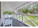 White porch with benches, table and chairs, overlooking green lawn at 5602 N Ola Ave, Tampa, FL 33604