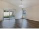 Bright living room with dark hardwood floors and sliding glass doors at 16707 Magnolia Reserve Pl, Wimauma, FL 33598