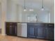 Kitchen island with dark cabinets, stainless steel dishwasher at 16707 Magnolia Reserve Pl, Wimauma, FL 33598