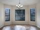 Bright dining room with three windows and a stylish chandelier at 16707 Magnolia Reserve Pl, Wimauma, FL 33598