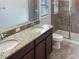 Bathroom with granite countertop, double sinks, and shower at 16707 Magnolia Reserve Pl, Wimauma, FL 33598