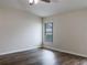 Empty bedroom with hardwood floors and a large window at 16707 Magnolia Reserve Pl, Wimauma, FL 33598