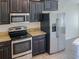 Stainless steel appliances and dark kitchen cabinets at 16707 Magnolia Reserve Pl, Wimauma, FL 33598