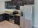 Kitchen with dark cabinets, granite counters, and stainless steel appliances at 16707 Magnolia Reserve Pl, Wimauma, FL 33598