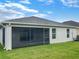 Home features a screened lanai and grassy backyard at 16707 Magnolia Reserve Pl, Wimauma, FL 33598