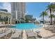 Upscale pool area with many tanning chairs, umbrellas and lush landscaping next to building at 1209 E Cumberland Ave # 807, Tampa, FL 33602