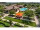 Beautiful aerial view of a community clubhouse, swimming pool, outdoor seating, and lush landscaping at 13939 Swallow Hill Dr, Lithia, FL 33547