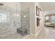 Bright bathroom with frameless glass shower, marble tile, and adjacent Primary bedroom at 13939 Swallow Hill Dr, Lithia, FL 33547