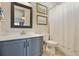 Bathroom featuring light vanity, framed mirror, and shower behind curtain at 13939 Swallow Hill Dr, Lithia, FL 33547