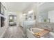 Bright bathroom features stylish tile floors, double vanity, and view to Primary bedroom at 13939 Swallow Hill Dr, Lithia, FL 33547