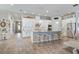 Open kitchen features large island, tile backsplash, stainless appliances, and wood-look floors at 13939 Swallow Hill Dr, Lithia, FL 33547