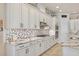 Modern kitchen featuring white cabinetry, granite countertops, and a stylish backsplash at 13939 Swallow Hill Dr, Lithia, FL 33547