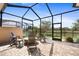 Enclosed patio with comfortable seating and a firepit table, overlooking a well manicured lawn at 13939 Swallow Hill Dr, Lithia, FL 33547