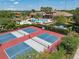 Aerial view of blue and red pickleball courts near the community center pool and manicured landscaping at 13939 Swallow Hill Dr, Lithia, FL 33547