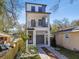 Modern three-story home featuring a balcony, garage, and manicured landscaping at 1734 W Cherry St, Tampa, FL 33607