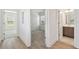 Hallway with wood floors leading to a bedroom with carpet and a bathroom with modern tile at 1734 W Cherry St, Tampa, FL 33607