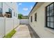 Side yard access with a long driveway and white vinyl fence at 626 E Davis Blvd, Tampa, FL 33606