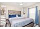 Bedroom with a tufted headboard and blue bedding at 11038 Ancient Futures Dr, Tampa, FL 33647