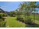 Landscaped backyard with a fence and a view of a pond at 13939 Swallow Hill Dr, Lithia, FL 33547