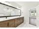 Bathroom featuring a large dual sink vanity, a large mirror, and marble floors at 7404 Newham Ln, Sarasota, FL 34240