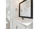 Bright bathroom featuring a white vanity, quartz countertop, and framed mirror at 7404 Newham Ln, Sarasota, FL 34240