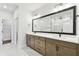 Bathroom featuring dual sink vanity, a large mirror, and marble floors at 7404 Newham Ln, Sarasota, FL 34240