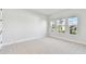 Bright bedroom features three large windows with outdoor views and neutral carpet at 7404 Newham Ln, Sarasota, FL 34240