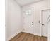 Clean, white entryway with a front door with glass and hardwood floors at 7404 Newham Ln, Sarasota, FL 34240