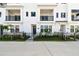 Beautiful townhouse features a black metal fence, manicured landscaping, and a private entryway at 7404 Newham Ln, Sarasota, FL 34240