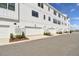 View of a row of attached garages for townhomes in a white exterior, set against a blue sky at 7404 Newham Ln, Sarasota, FL 34240